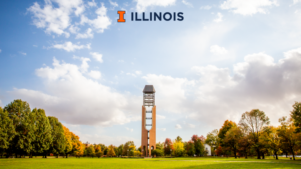 View of the McFarland Memorial Bell Tower at the University of Illinois, surrounded by colorful autumn trees under a bright blue sky with scattered clouds.