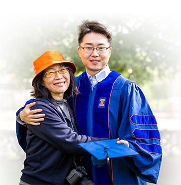 A graduate hugging family